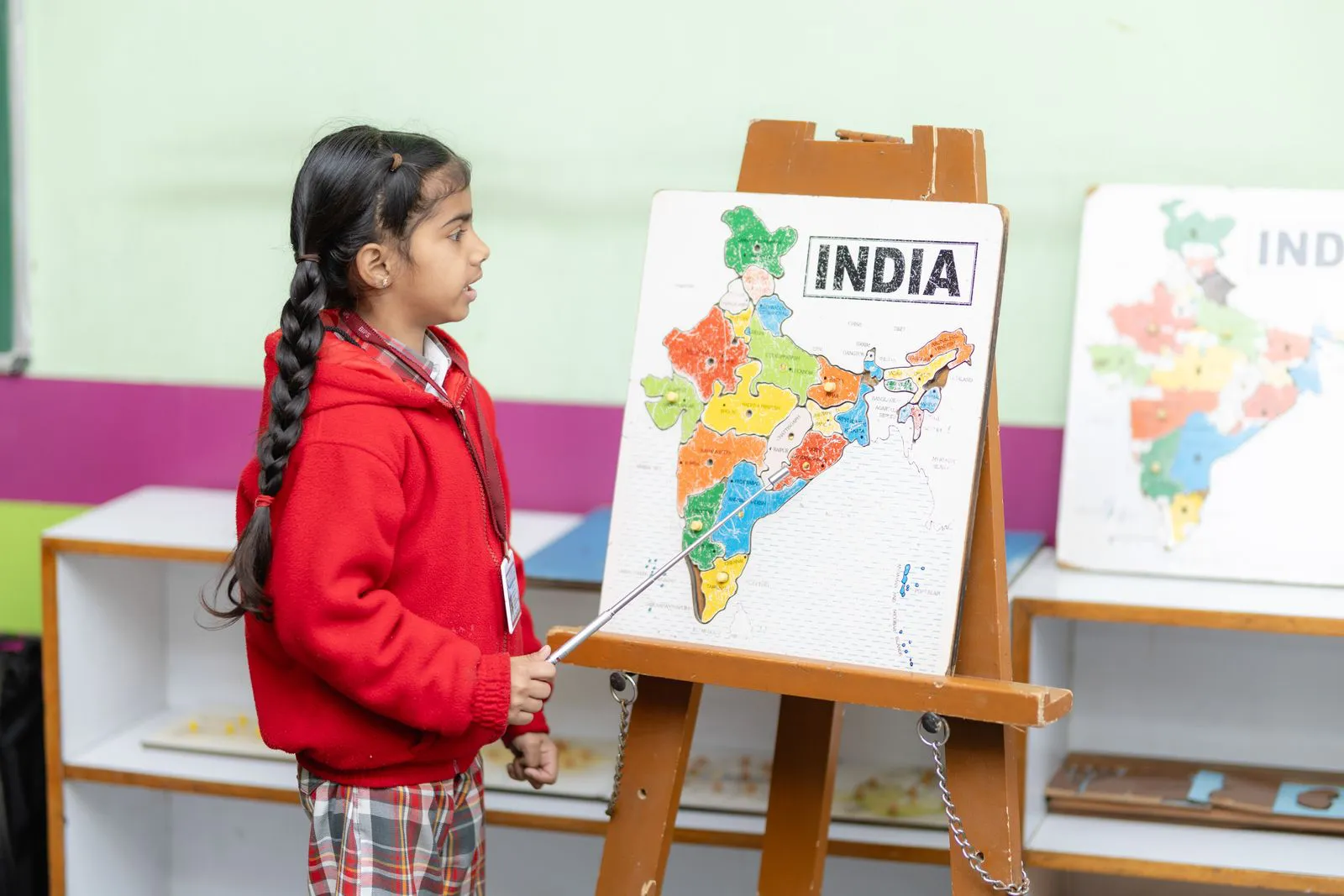 A girl pointing at a map of India on an easel